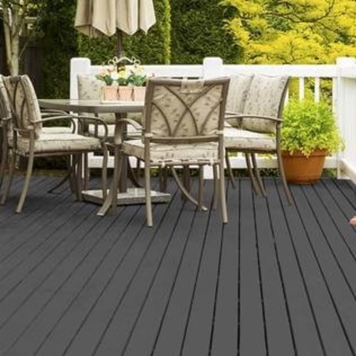 A deck stained in a dark gray stain with table and chairs